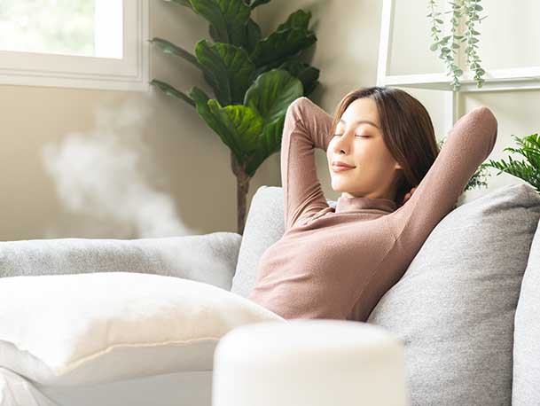 Woman breathing easily as she diffused essential oils that are known to improve the quality of indoor air.