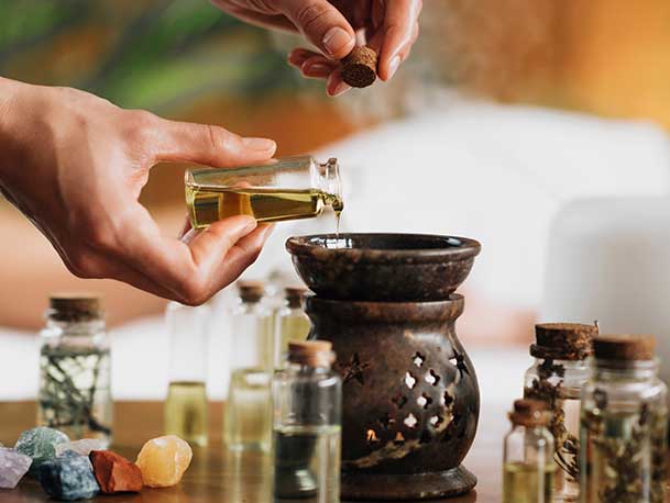 Hands pouring essential oils into diffuser.