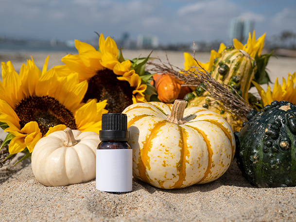 Bottle of essential oil with pumpkins and sunflowers