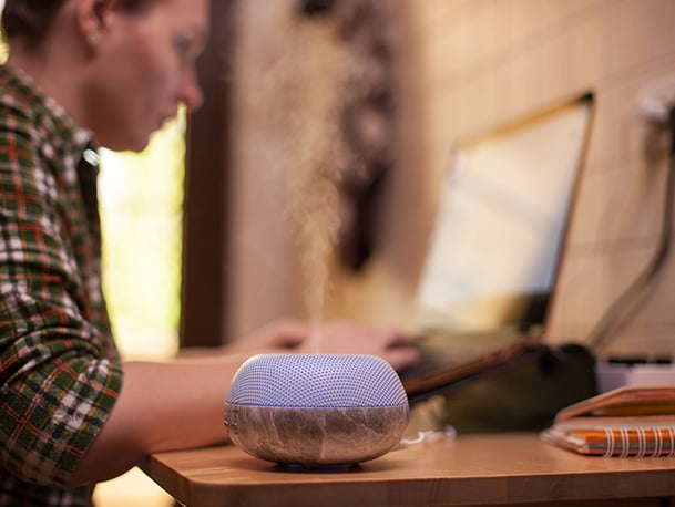 A person studying next to essential oils diffuser